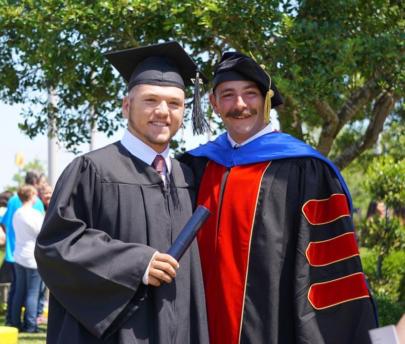 Graduating student with instructor outside